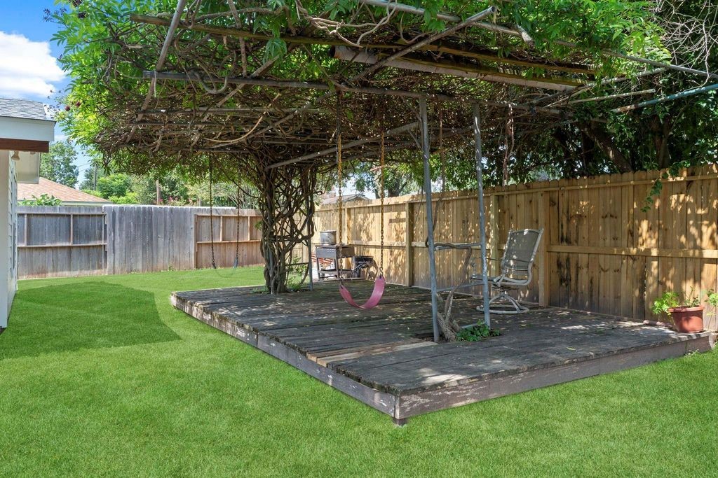 8918 Grape Street Houston, TX 77036 - Photo 38 of 40 a view of a backyard with a wooden fence and a table and chair