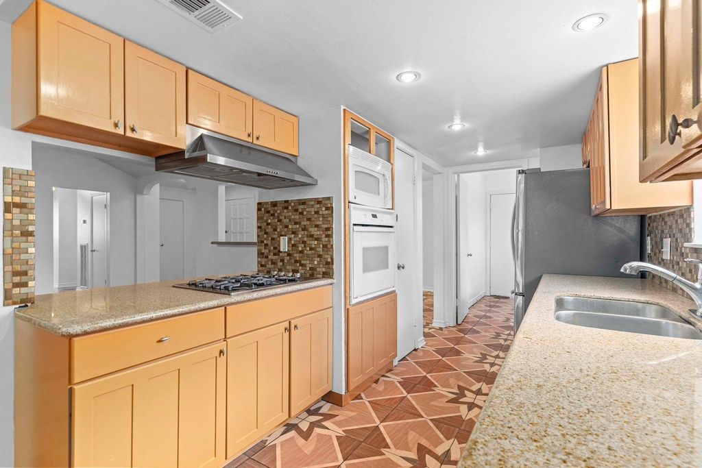 8918 Grape Street Houston, TX 77036 - Photo 10 of 40 a kitchen with granite countertop sink and cabinets