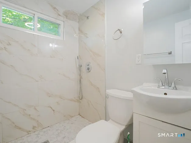 a bathroom with a sink a toilet and shower