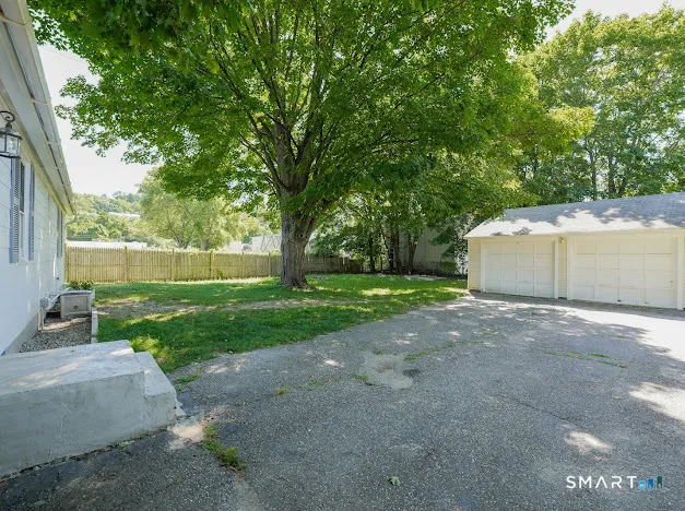 a view of a yard with a house and a large tree
