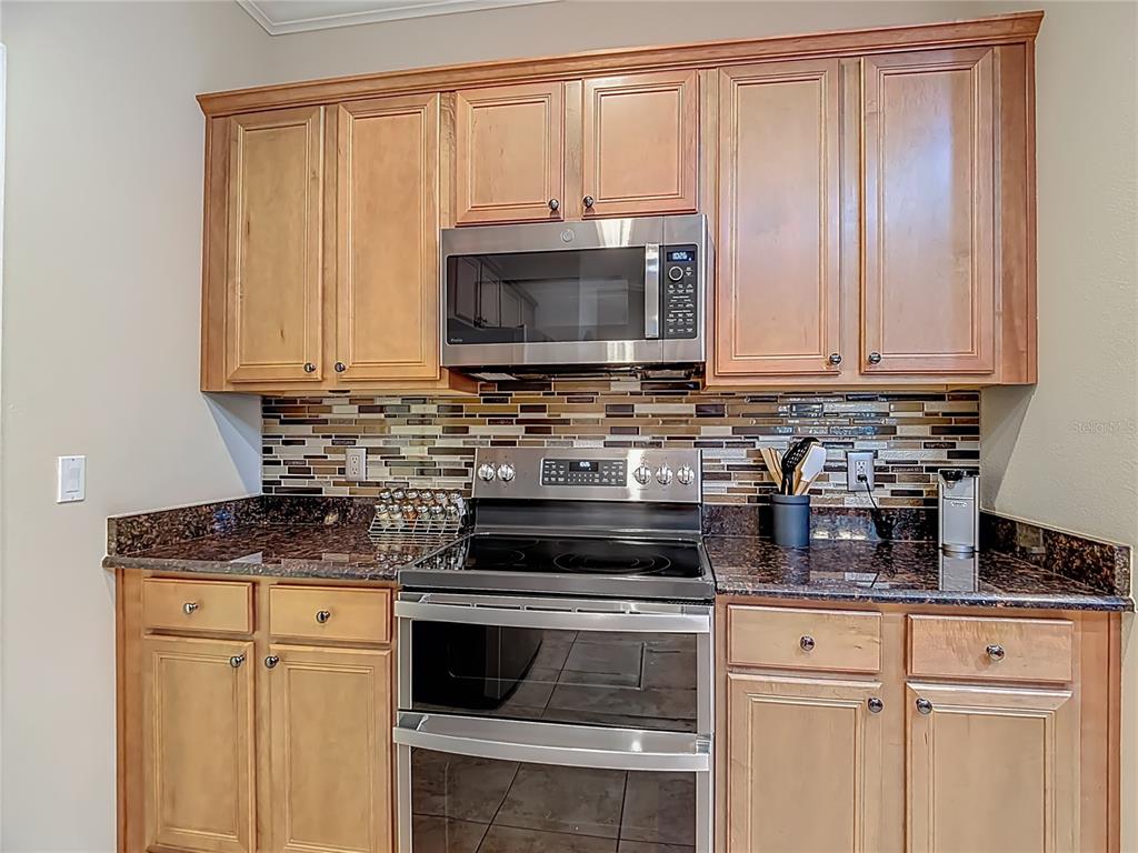 277 Magneta Loop Auburndale, FL 33823 - Photo 11 of 58 a kitchen with stainless steel appliances granite countertop a stove a sink and a microwave