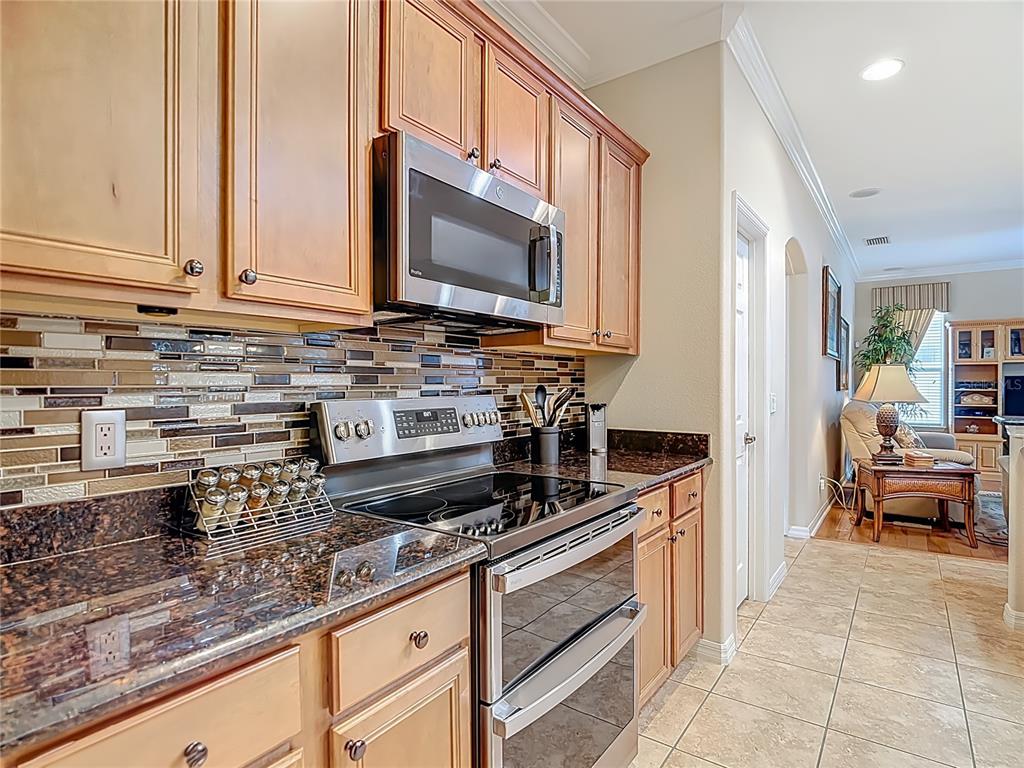 277 Magneta Loop Auburndale, FL 33823 - Photo 13 of 58 a kitchen with stainless steel appliances granite countertop a sink stove and microwave