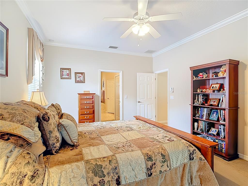 277 Magneta Loop Auburndale, FL 33823 - Photo 24 of 58 a bedroom with a large bed and a chandelier