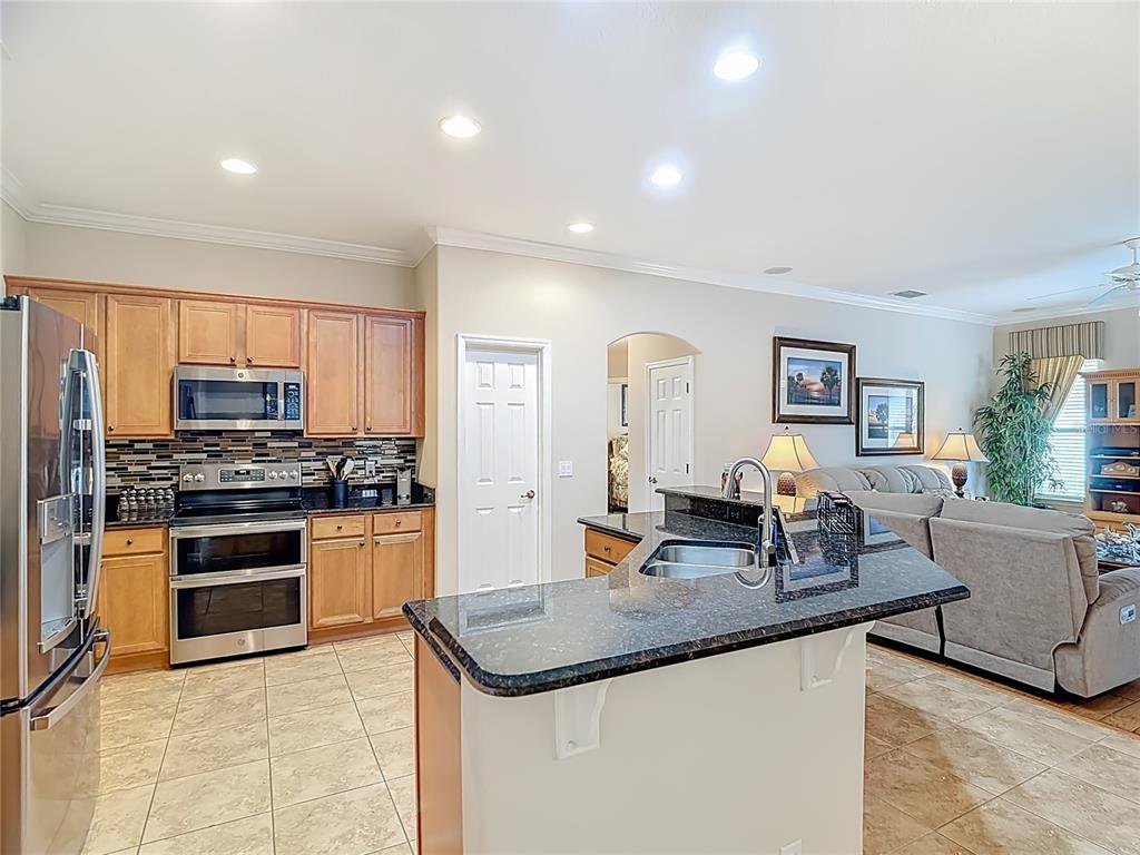 277 Magneta Loop Auburndale, FL 33823 - Photo 8 of 58 a kitchen with stainless steel appliances granite countertop a sink stove and refrigerator