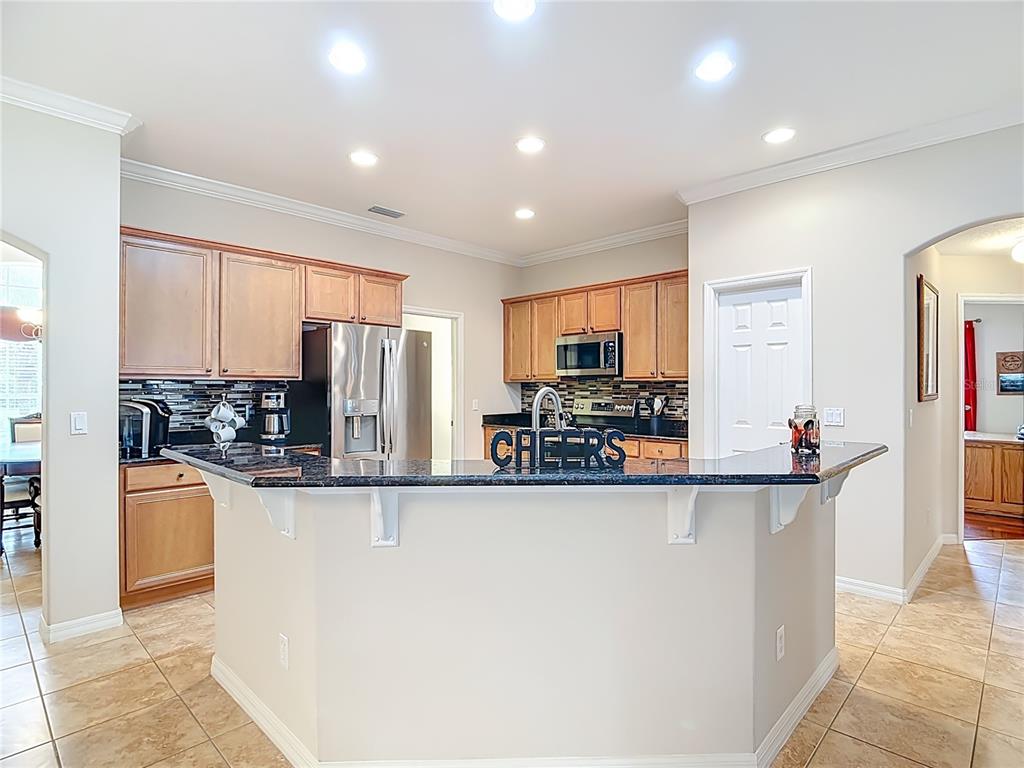 277 Magneta Loop Auburndale, FL 33823 - Photo 9 of 58 a kitchen with stainless steel appliances granite countertop a refrigerator and a stove