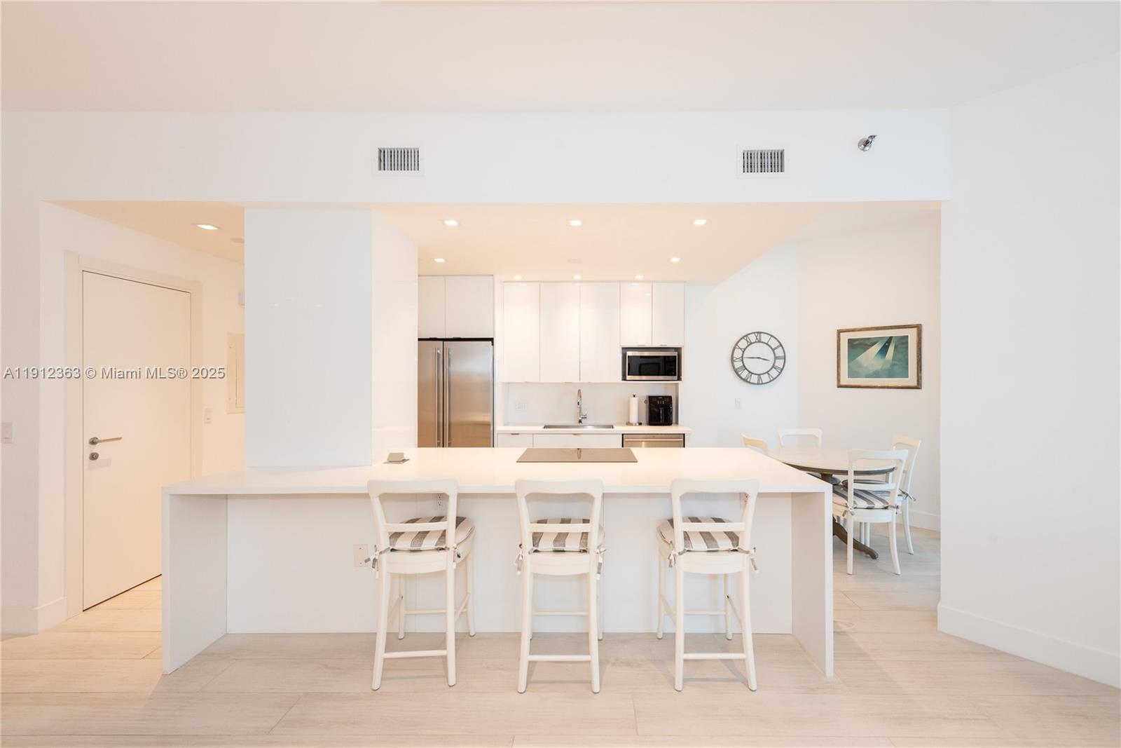 8925 Collins Avenue, Unit 11C Surfside, FL 33154 - Photo 15 of 36 a dining room with furniture and a kitchen view
