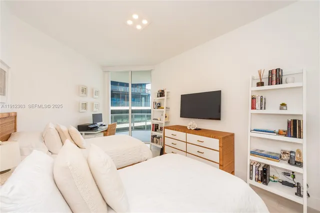 a bedroom with two bed and a flat screen tv