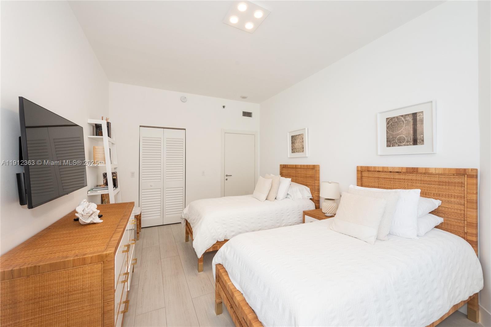 8925 Collins Avenue, Unit 11C Surfside, FL 33154 - Photo 17 of 36 a bedroom with two bed and a flat screen tv