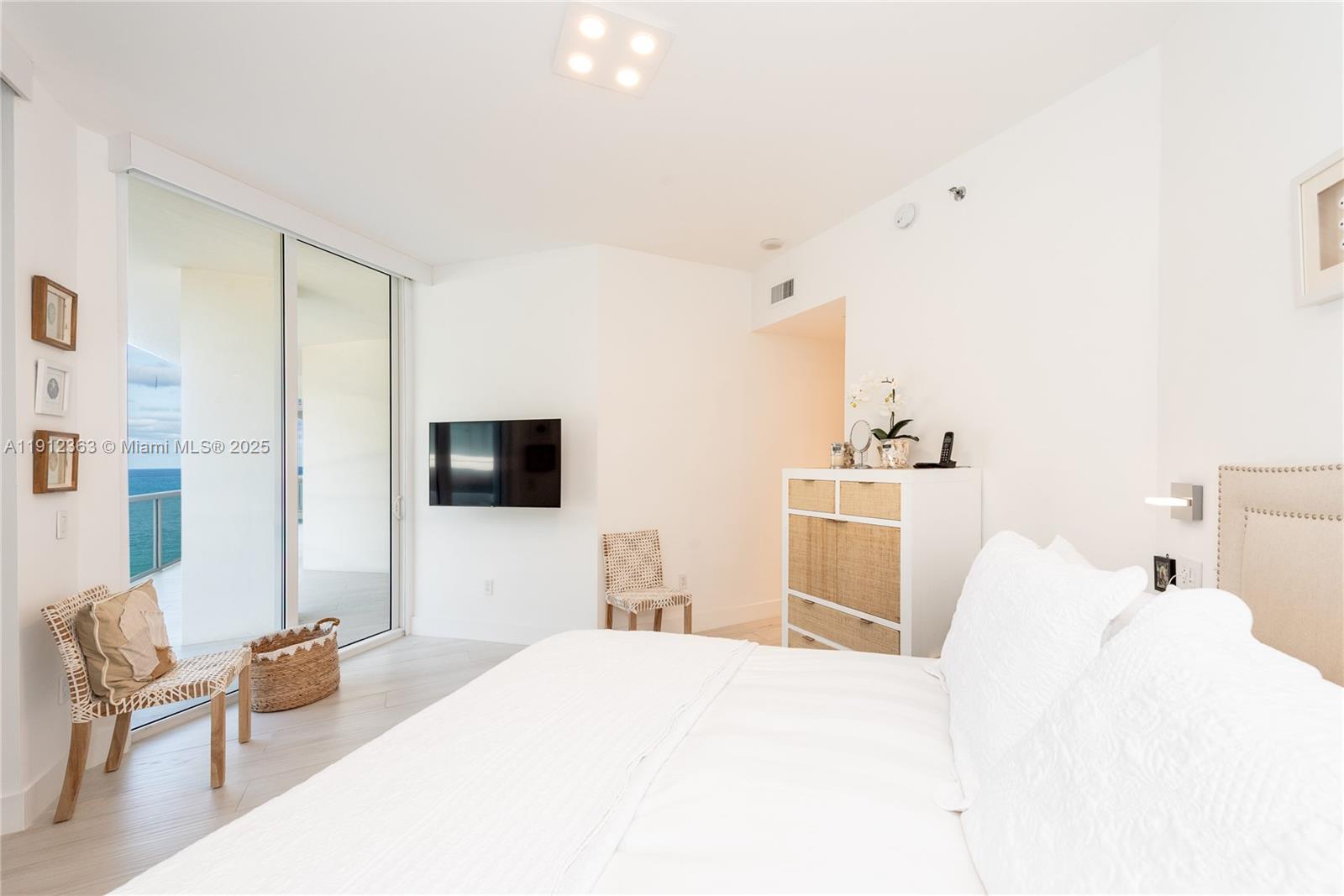 8925 Collins Avenue, Unit 11C Surfside, FL 33154 - Photo 21 of 36 a bedroom with a bed and a flat screen tv