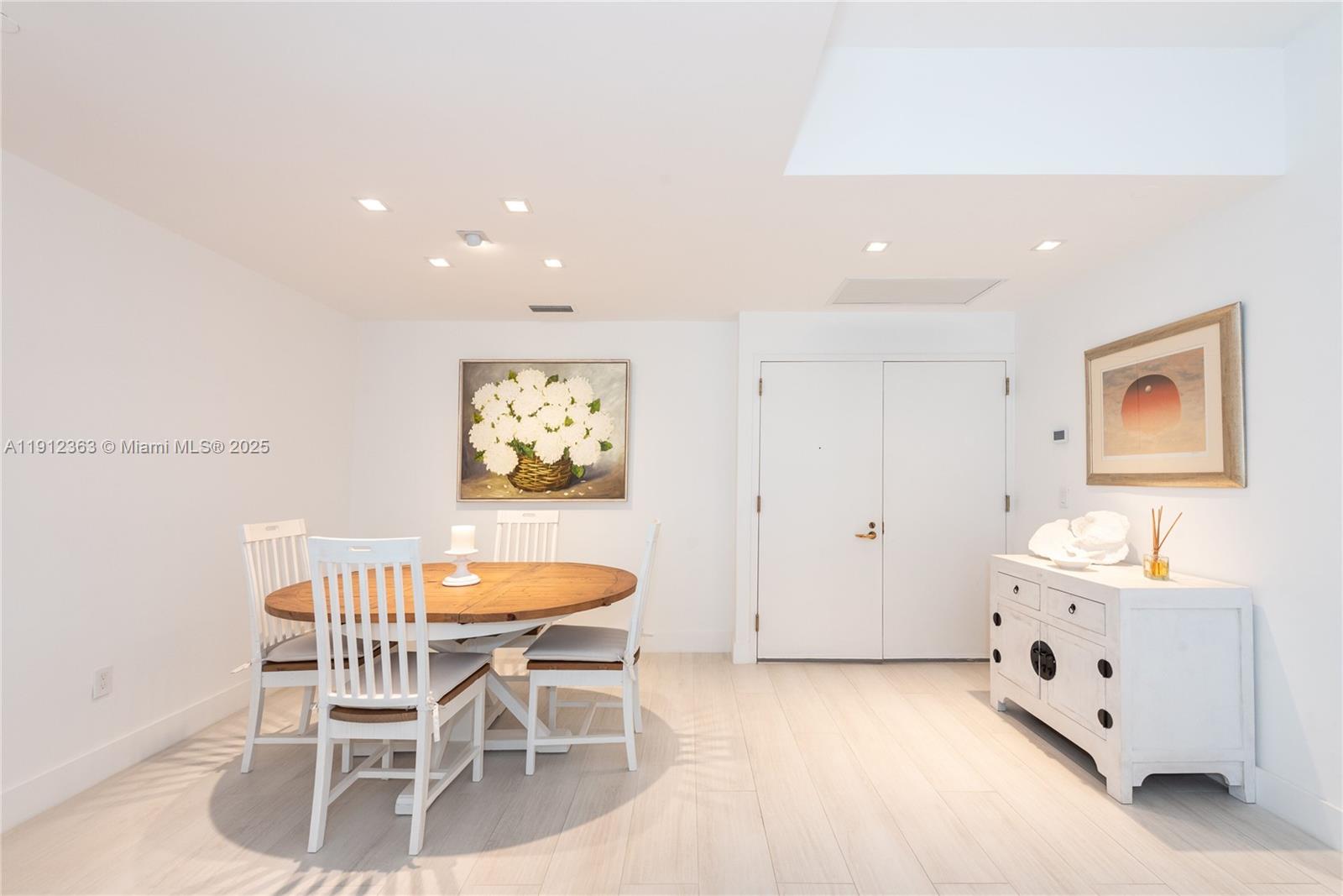 8925 Collins Avenue, Unit 11C Surfside, FL 33154 - Photo 5 of 36 a dining room with furniture and a chandelier