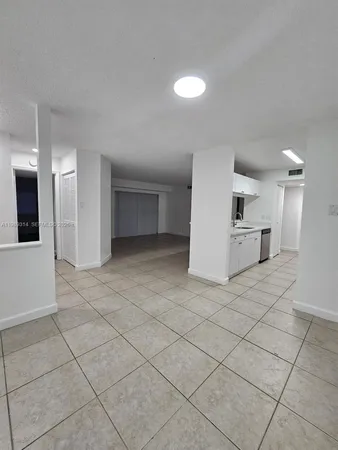 a view of a kitchen with a sink and a refrigerator
