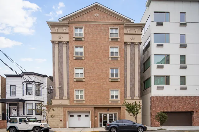 a front view of a residential apartment building with a yard