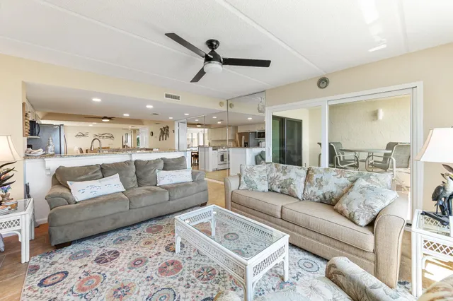 a living room with furniture and a view of kitchen