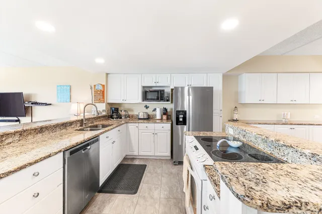 a kitchen with a sink stove top oven and refrigerator