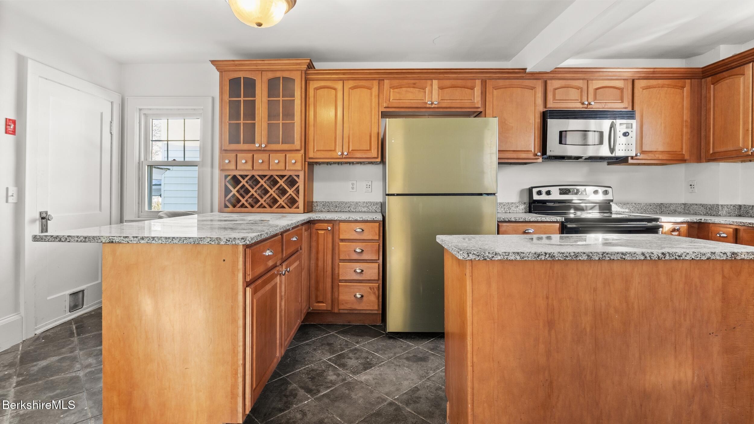 121 Edward Avenue Pittsfield, MA 01201 - Photo 7 of 22 a kitchen with stainless steel appliances granite countertop a refrigerator a stove a sink dishwasher and wooden cabinets with wooden floor