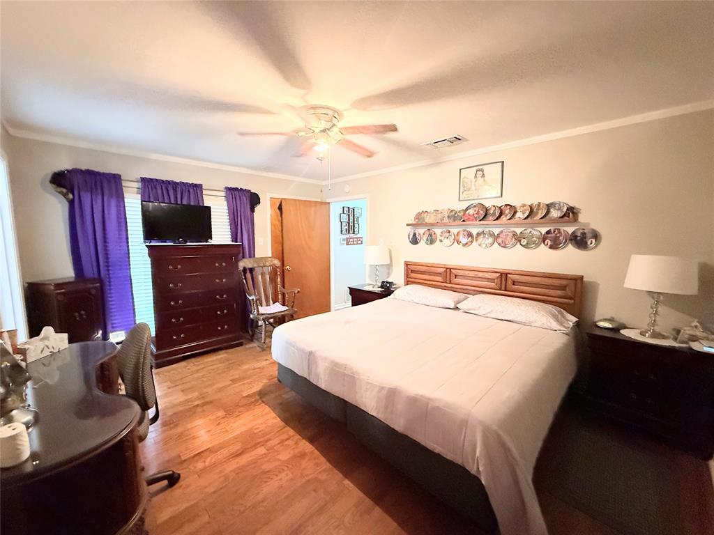 112 Meadow Lane Groesbeck, TX 76642 - Photo 19 of 37 a spacious bedroom with a bed and a flat screen tv