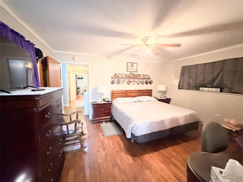 112 Meadow Lane Groesbeck, TX 76642 - Photo 21 of 37 a spacious bedroom with a bed and flat screen tv