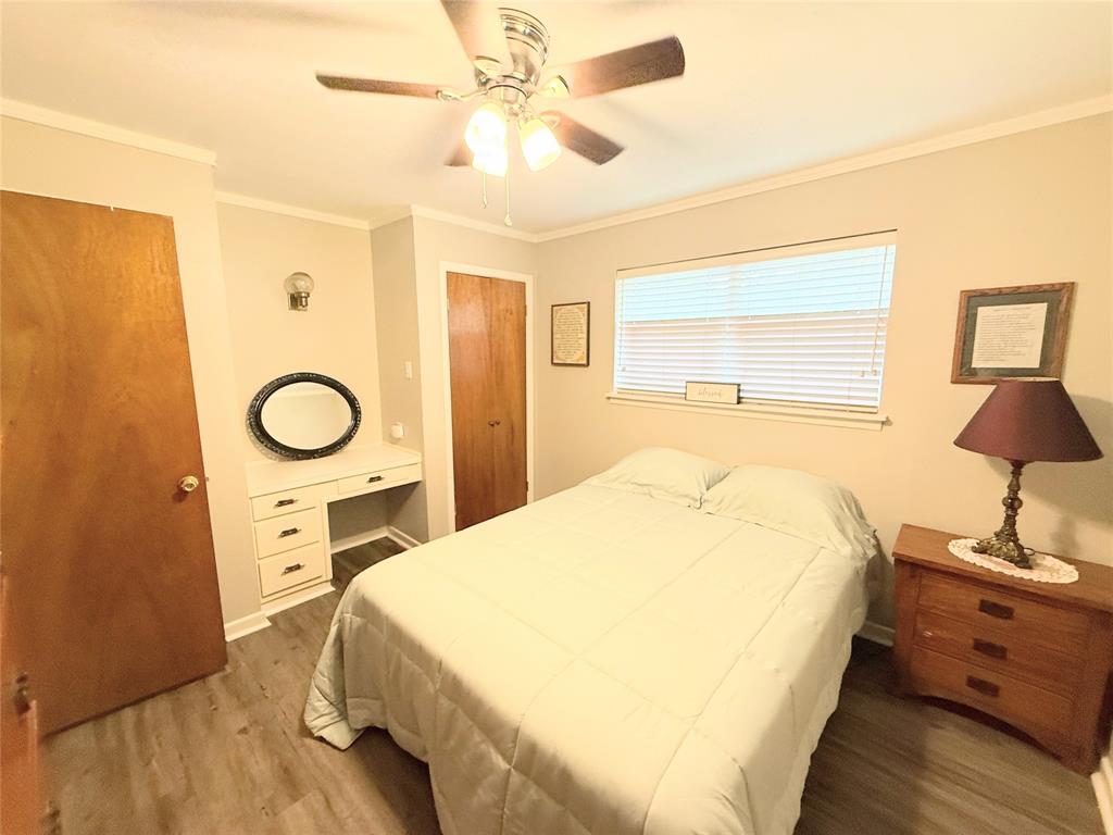 112 Meadow Lane Groesbeck, TX 76642 - Photo 25 of 37 a spacious bedroom with a bed and a chandelier