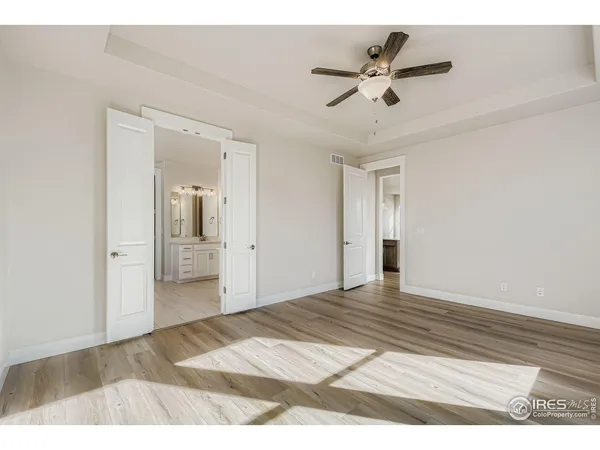 a view of a livingroom with a ceiling fan & kitchen space with a sink