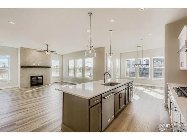 a kitchen with granite countertop a stove a sink and wooden floor