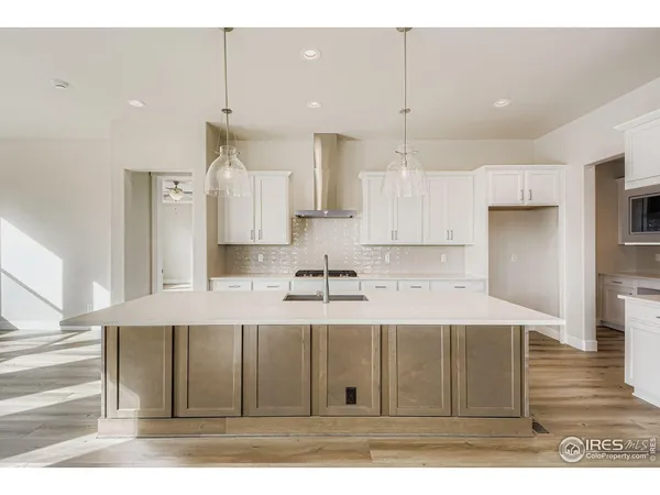 a kitchen with kitchen island white cabinets and stainless steel appliances