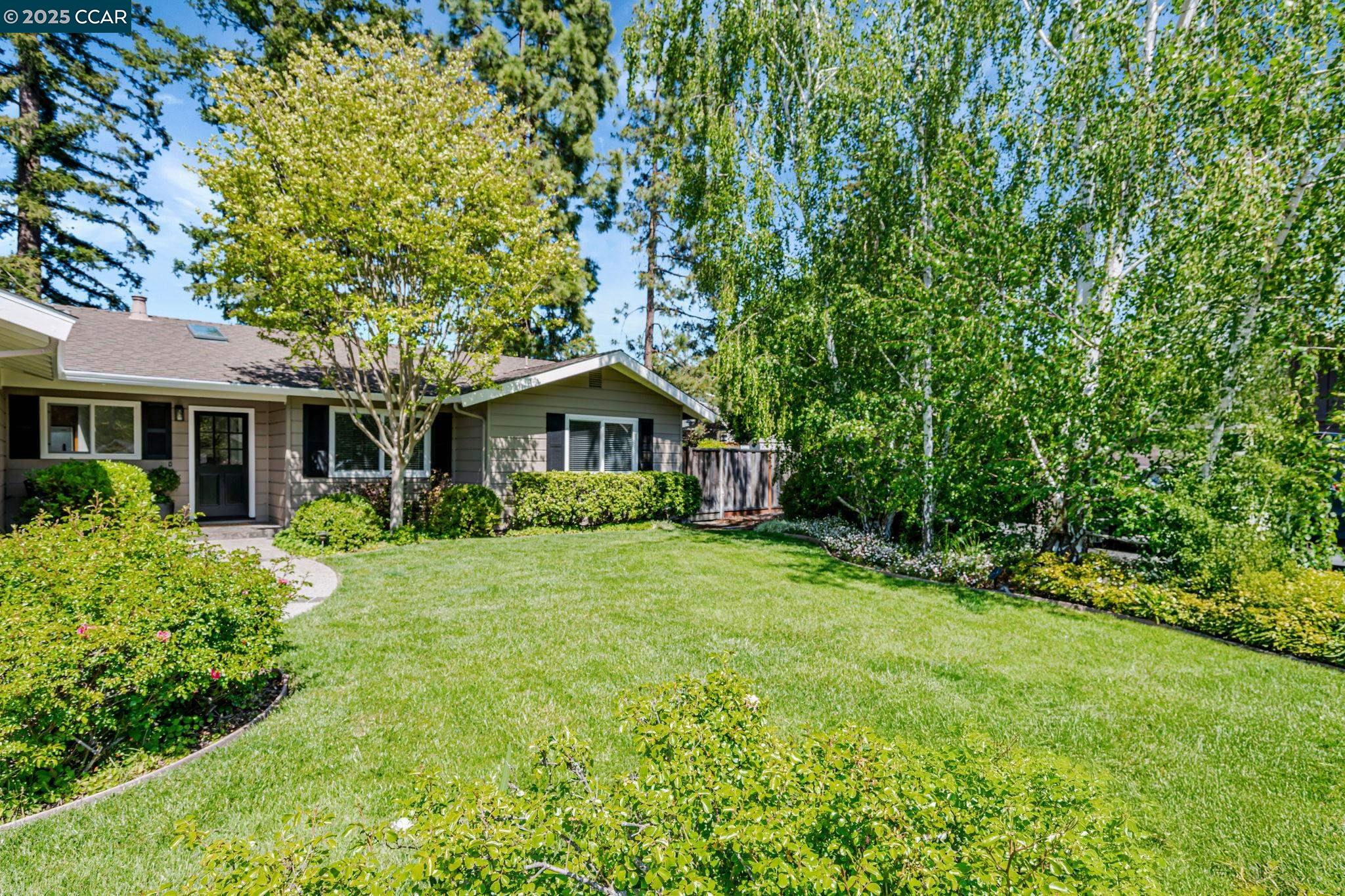a front view of a house with a yard and trees