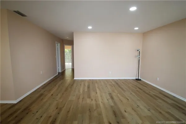 a view of an empty room with wooden floor