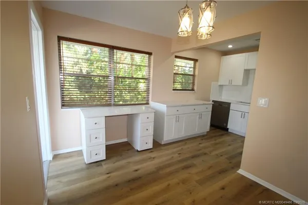a view of a kitchen with wooden floor and a window