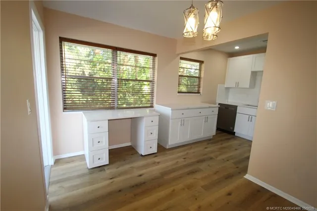 a view of a kitchen with wooden floor and a window
