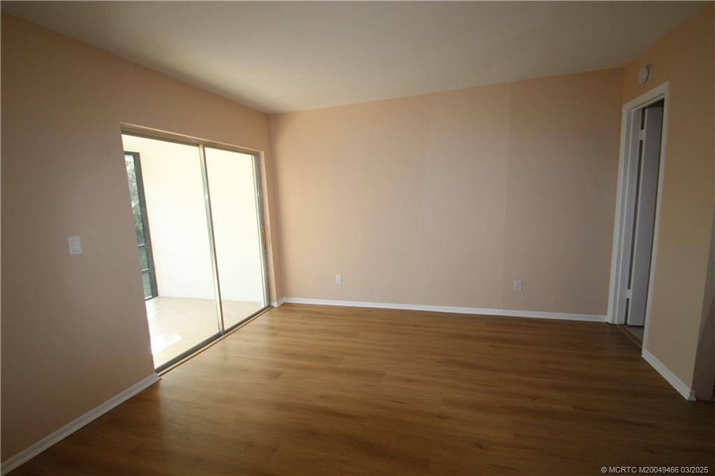 2929 Southeast Ocean Boulevard, Unit 13110 Stuart, FL 34996 - Photo 8 of 25 an empty room with wooden floor and windows