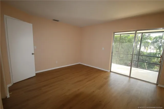 wooden floor in an empty room with a window