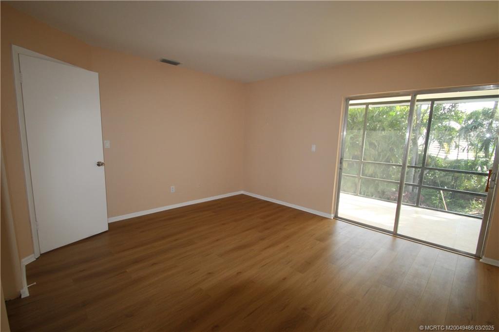 2929 Southeast Ocean Boulevard, Unit 13110 Stuart, FL 34996 - Photo 9 of 25 wooden floor in an empty room with a window