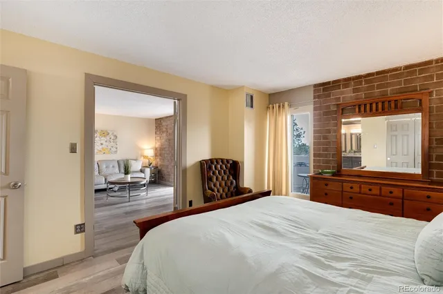 a bedroom with a bed and a large mirror with a dresser