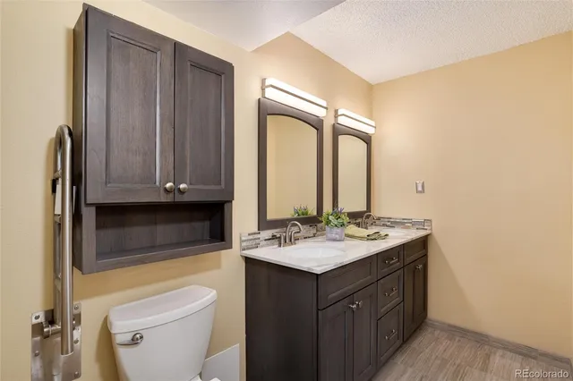 a bathroom with a sink vanity granite and toilet