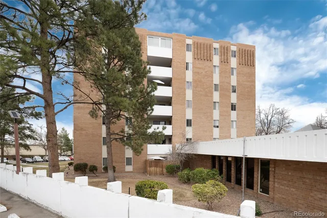 a view of tall building with a large tree