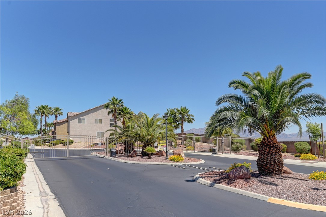 4613 Rising Cove Street Las Vegas, NV 89129 - Photo 20 of 20 Secure community entrance with palm trees and a clear blue sky.