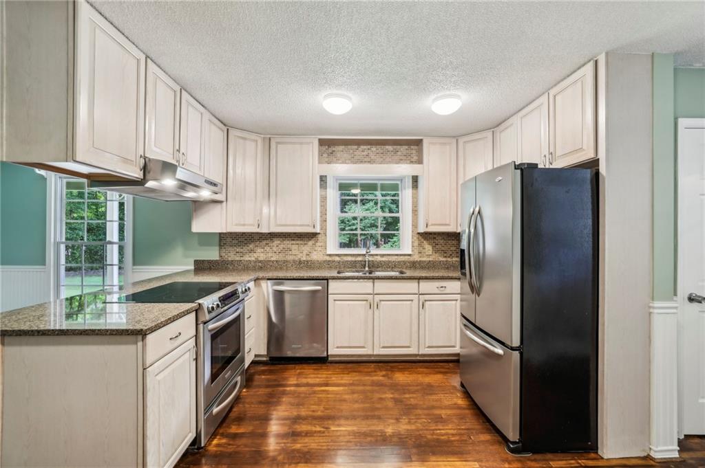 4645 Shallowford Road Roswell, GA 30075 - Photo 11 of 34 a kitchen with stainless steel appliances granite countertop a refrigerator sink and stove