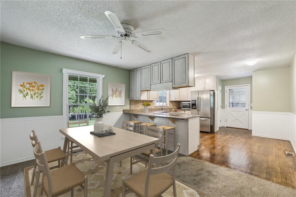 4645 Shallowford Road Roswell, GA 30075 - Photo 8 of 34 a kitchen with a dining table chairs and white cabinets
