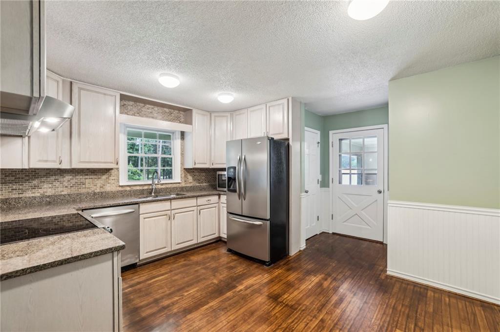 4645 Shallowford Road Roswell, GA 30075 - Photo 10 of 34 a kitchen with a sink wooden floor and stainless steel appliances