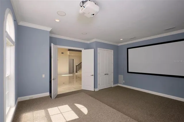 an empty room with wooden floor a ceiling fan and windows