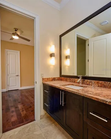 a bathroom with a granite countertop sink and a toilet
