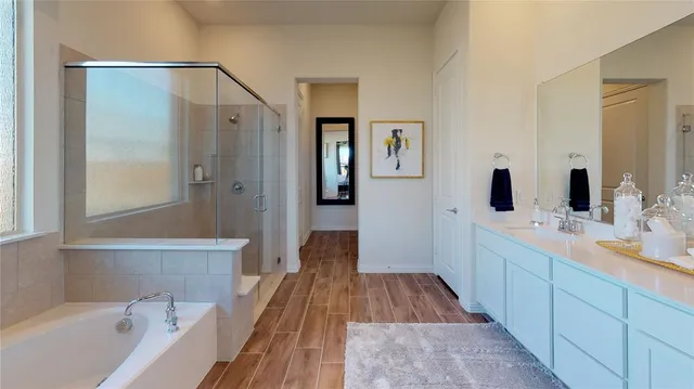 a spacious bathroom with a tub sink and mirror