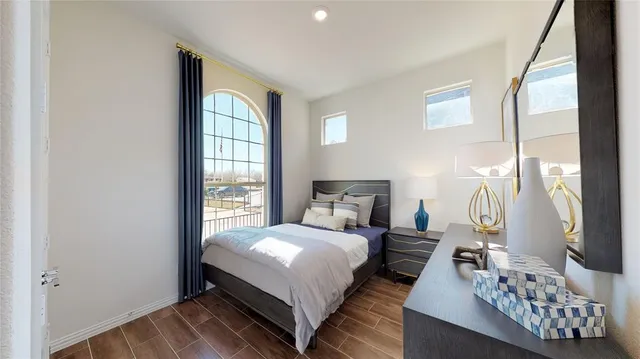 a bedroom with a bed wooden floor and window