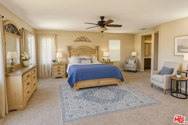 a spacious bedroom with a bed a couch and dresser