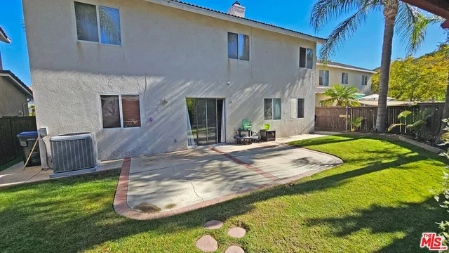 a view of a house with a yard patio and fire pit