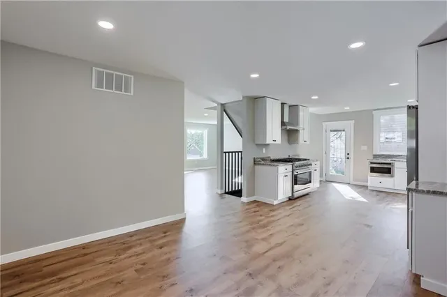 a view of kitchen with stainless steel appliances kitchen island wooden floor and window
