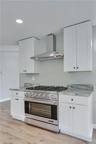 a kitchen with granite countertop white cabinets and stainless steel appliances