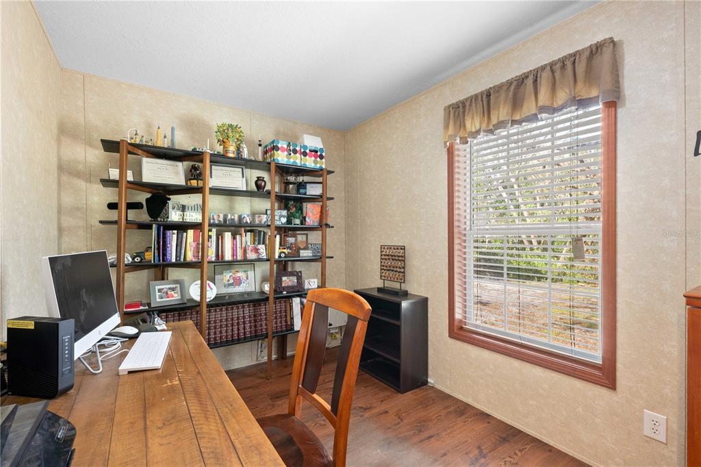 a view of a workspace with furniture and a bookshelf