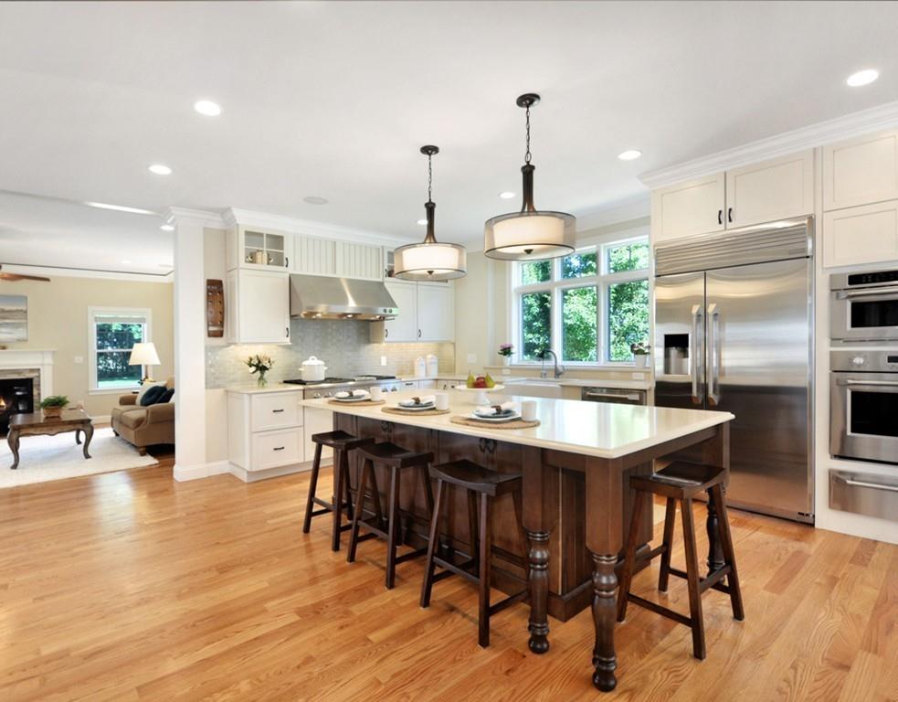 30 Nancy Road Concord, MA 01742 - Photo 4 of 26 a kitchen with stainless steel appliances granite countertop a stove a refrigerator a kitchen island a dining table and chairs with wooden floor