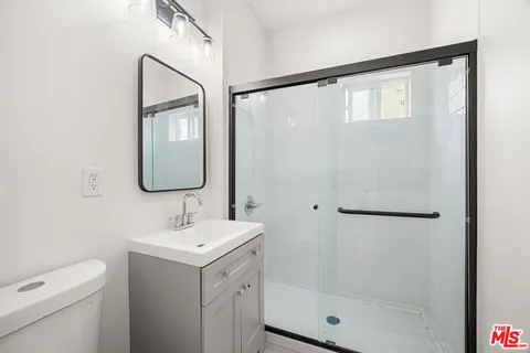 a bathroom with a shower sink and mirror